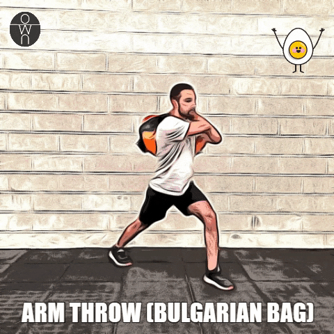 Avec un sac bulgare, un coach sportif montre les mouvements du arm throw.