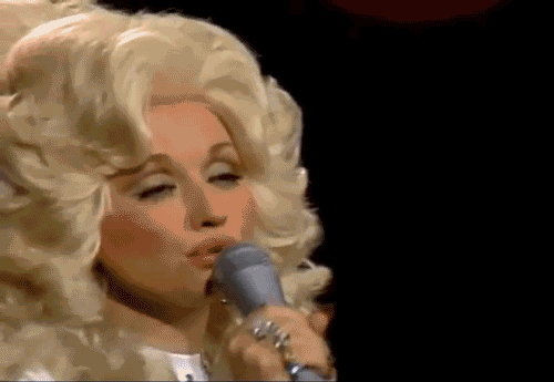 Dolly Parton singing into a microphone. 