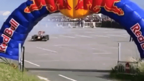 Guy jump over F1 race car
