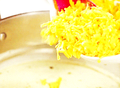 A gif featuring grated cheese being put in a pan