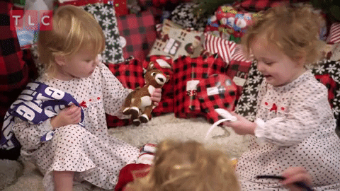 niñas chiquitas abriendo sus regalos de navidad, felices