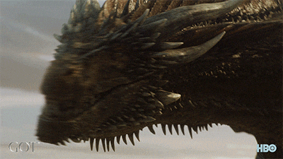 the dragon Drogon roars loudly at a group of people, who kneel in submission. 