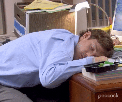 Worker sleeping on office desk.