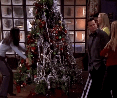 Gif of Monica from Friends rotating a heavily decorated Christmas tree