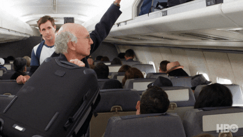 cena da série Curb Your Enthusiasm em que Larry David enfia a mala de qualquer jeito no bagageiro de um avião