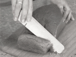 Black and white GIF of someone trying to cut bread with a doorstop.