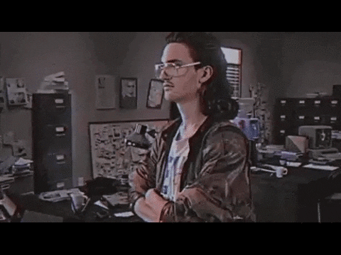 A man in a mullet, glasses and a leather jacket turns to the camera. The word HACKERMAN flashes onto the screen.