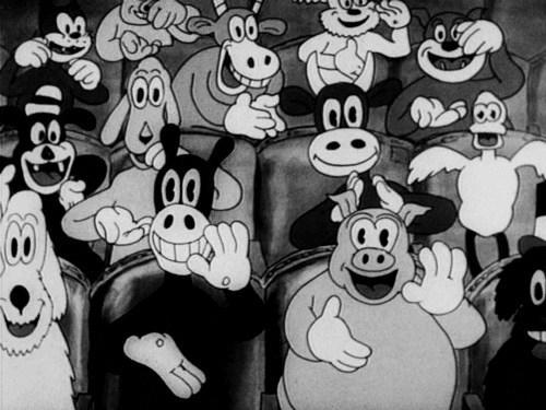 black and white animal characters in an audience clapping and smiling