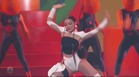 Gif of Doja Cat dancing on stage. There are three girls with red hats dancing in the back.