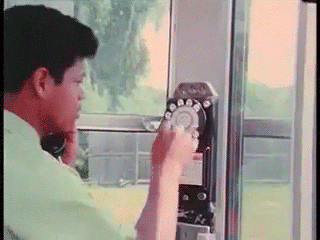 GIF of man in green shirt using old phone