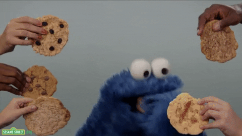 Giphy of multiple hands holding out cookies to Cookie Monster. Cookie Monster grabs and eats them all.
