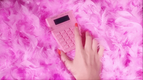 woman typing in numbers on a pink calculator to determine the cost of her social media strategy