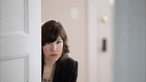 woman peeking out from behind a door to analyze competitors with competitive analysis and SEO