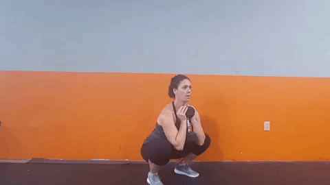 Goblet squat with dumbbell: Stand with feet hip-width apart, dumbbell held at chest with bent elbows. Sit down and back, all the way until elbows touch inside of knees. Stand back up, driving through heels.