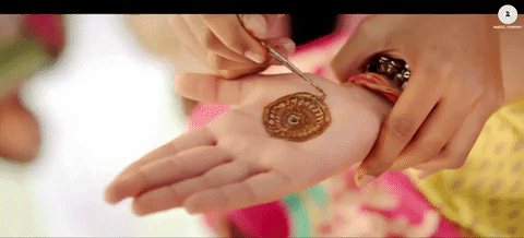 Person applying henna design on hand