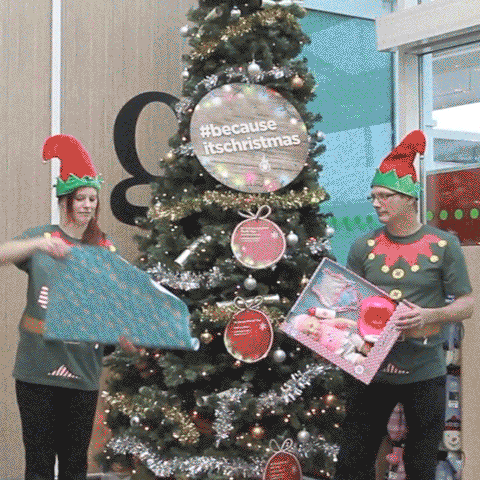 Source: Giphy. Description: a trio of people dressed as Santa's elves wrapping a present.
