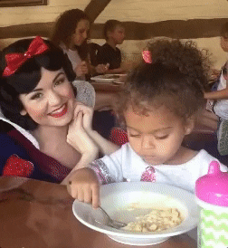 Gif of a little girl angrily staring forward as a dressed-up Snow White actor attempts to make her smile -- first year as a teacher