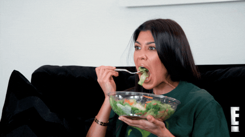 GIF of Kourtney Kardashian eating a salad at home.