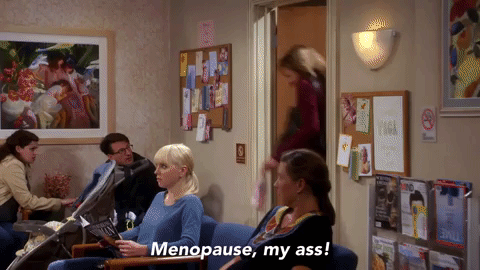 Woman running across a doctor's office saying Menopause, my ass