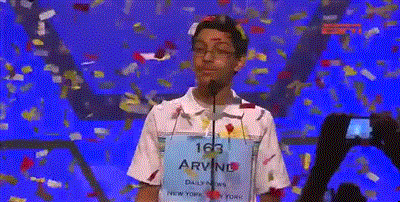 A GIF of a young kid on a TV show. Celebratory confetti is raining down on him.