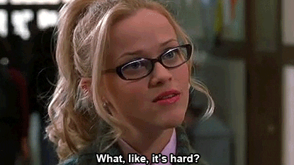 Elle Woods, wearing glasses and a blonde high ponytail, asks "What, like it's hard?"
