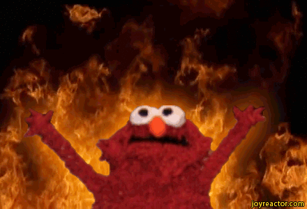 Elmo standing in front of burning flames