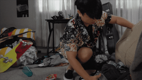 Un petit garçon qui essaye de ranger sa chambre 